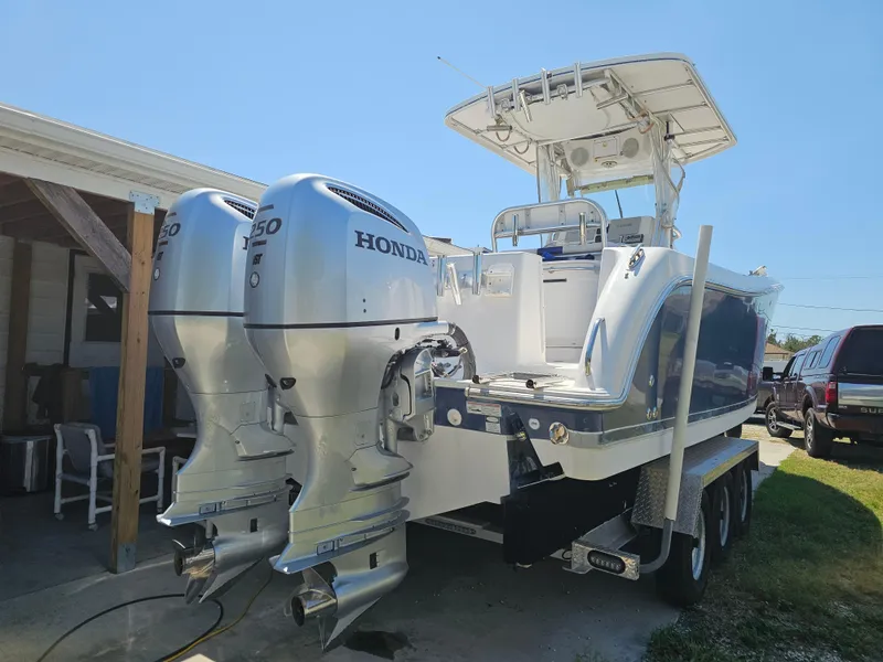 Slide: The Image of 2008 Pro-Line 29 Grande Sport boat with dual Honda 250 outboard engines on a trailer. - 27