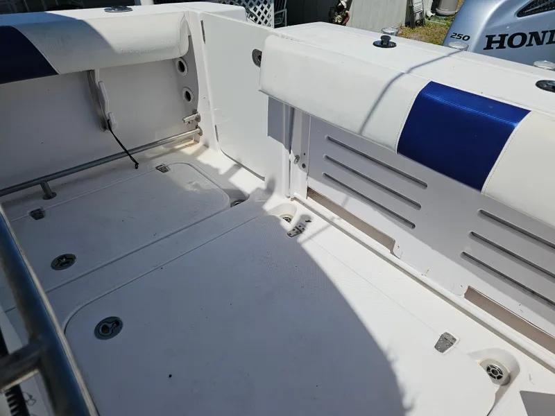 Slide: The Image of 2008 Pro-Line 29 Grande Sport boat interior with white seating and Honda engine. - 4