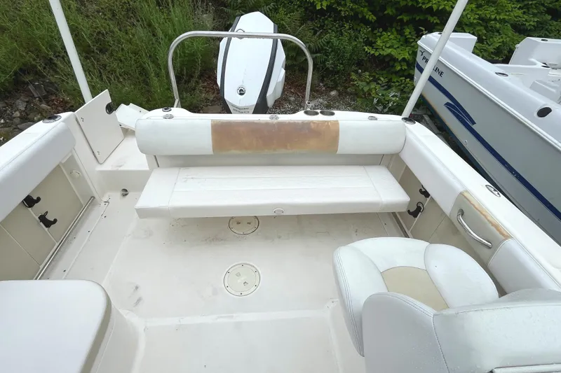 Slide: The Image of 2016 Robalo R227 Dual Console boat interior with seating and outboard motor. - 11