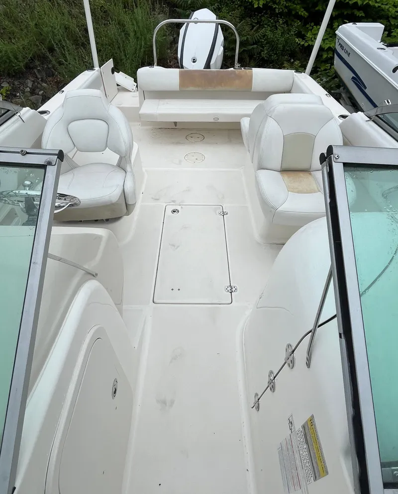 Slide: The Image of 2016 Robalo R227 Dual Console boat interior with white seating and open deck layout. - 14