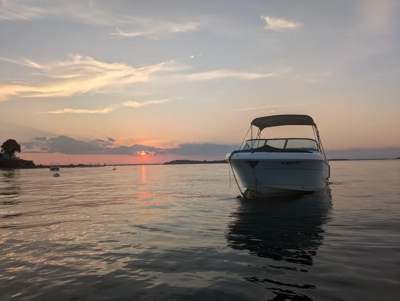 Slide: The Image of 2016 Robalo R227 Dual Console boat at sunset on calm waters. - 4