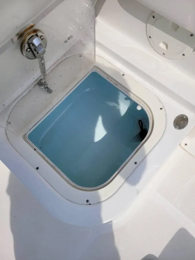 Slide: The Image of 2016 Robalo R227 Dual Console livewell with open lid and water inside. - 9