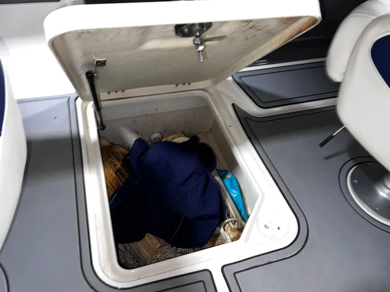 Slide: The Image of Open storage compartment in 2008 Monterey 214FSC boat, containing various items. - 8