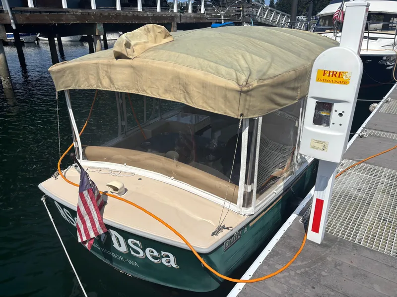 Slide: The Image of 2009 Duffy Snug Harbor boat docked, covered with beige canopy, American flag displayed. - 2