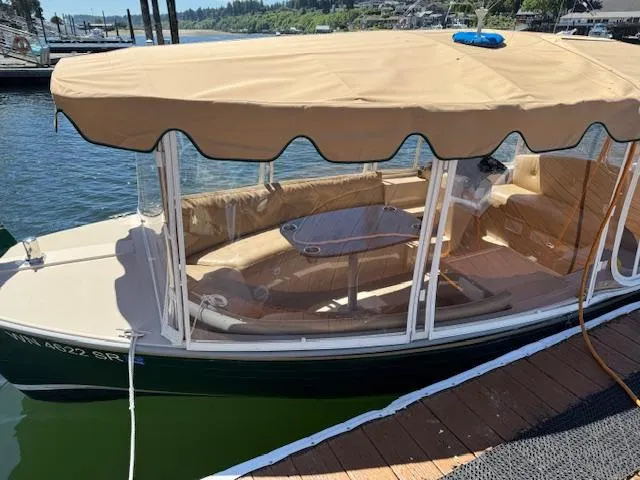 Slide: The Image of 2009 Duffy Snug Harbor boat with tan canopy docked by the water. - 4