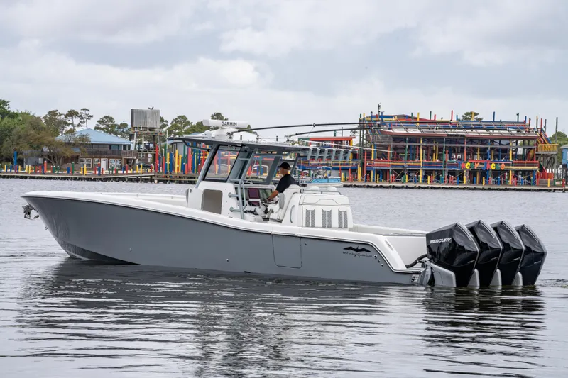 Slide: The Image of 2022 Invincible 39 Open Fisherman boat with four engines on a calm waterway. - 1