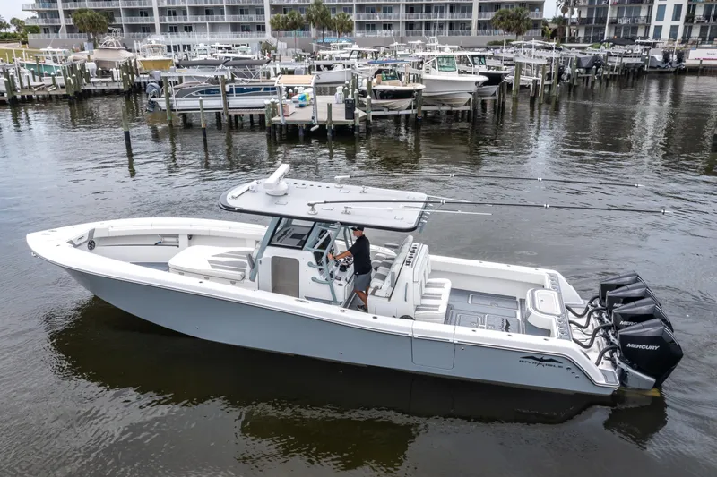 Slide: The Image of 2022 Invincible 39 Open Fisherman boat docked in marina, featuring triple Mercury engines. - 3