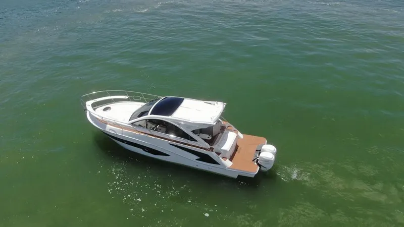 Slide: The Image of 2023 Evolve 400HT boat cruising on calm green waters. - 14