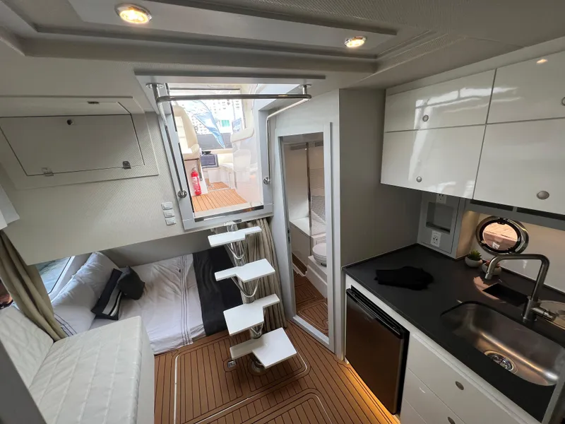 Slide: The Image of 2023 Evolve 400HT yacht interior with modern kitchen, compact living space, and wooden flooring. - 23