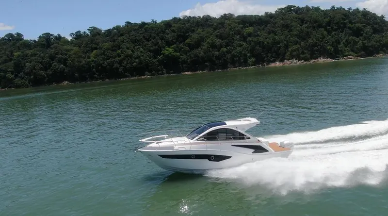 Slide: The Image of 2023 Evolve 400HT yacht cruising on a scenic lake with lush green forest backdrop. - 7