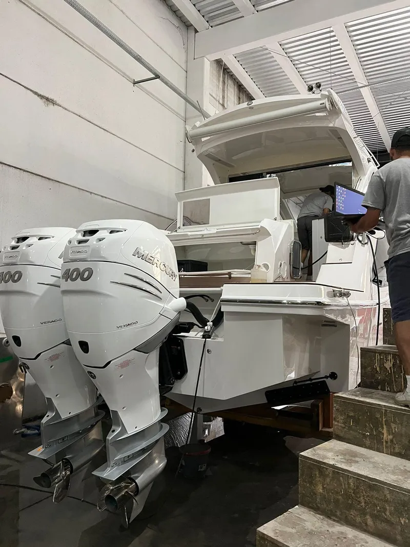 Slide: The Image of 2023 Evolve 400HT boat with dual outboard motors in a workshop setting. - 9