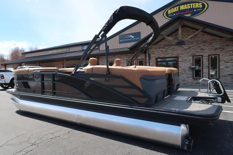 Slide: The Image of 2025 Bennington M Quad Bench 22 MFB pontoon boat parked outside dealership. - 5