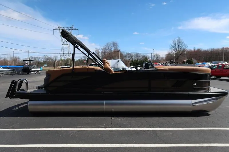 Slide: The Image of 2025 Bennington M Quad Bench 22 MFB pontoon boat on display in a parking lot. - 6