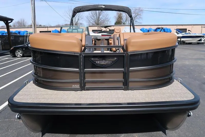 Slide: The Image of 2025 Bennington M Quad Bench 22 MFB pontoon boat, rear view in a parking lot. - 8