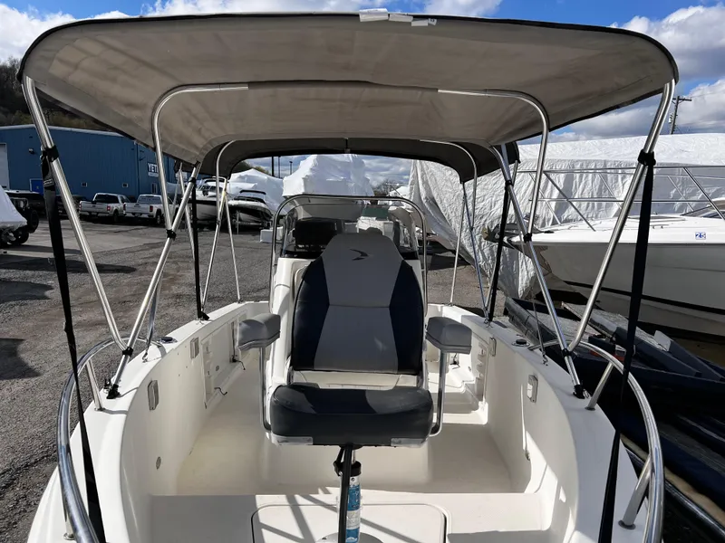 Slide: The Image of 2001 Aquasport 190 Osprey boat with canopy and seating, docked outdoors. - 3