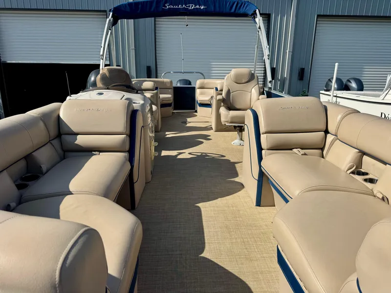 Slide: The Image of 2018 South Bay 500 SERIES 2.75 pontoon boat with beige seating and blue canopy. - 10