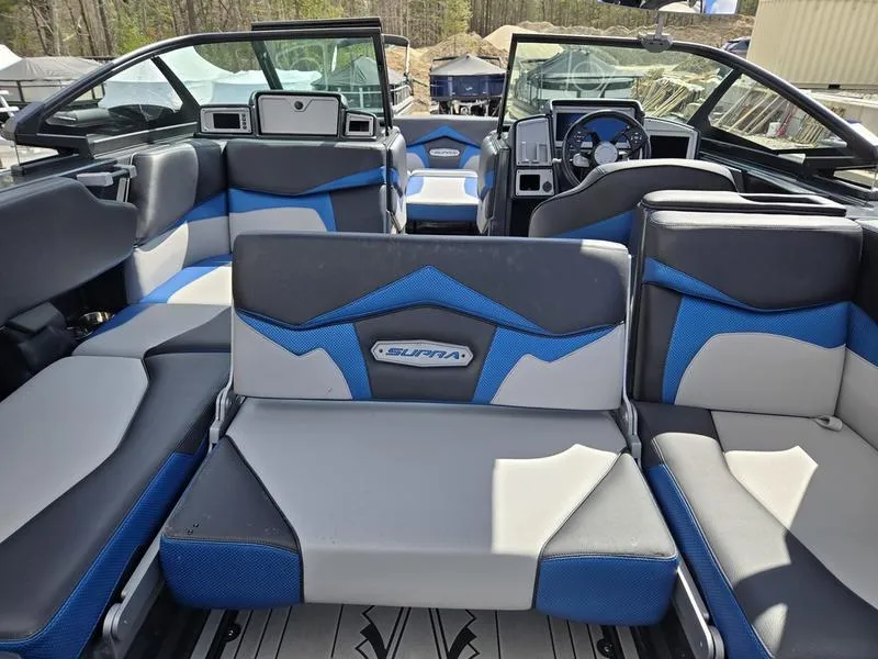 Slide: The Image of 2019 Supra SA boat interior with blue and gray seating, modern dashboard, and spacious layout. - 11