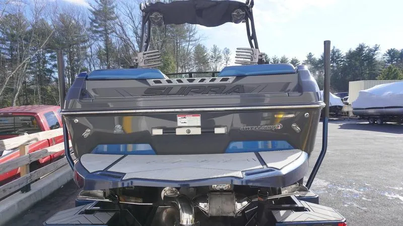 Slide: The Image of 2019 Supra SA boat rear view, parked outdoors, showcasing sleek design and powerful engine. - 23