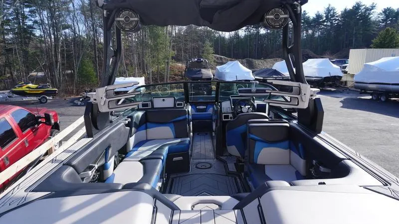 Slide: The Image of 2019 Supra SA boat interior with blue and gray seating, parked outdoors. - 24