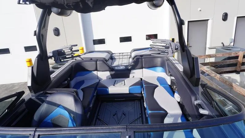 Slide: The Image of 2019 Supra SA boat interior with blue and gray seating, docked near a building. - 25