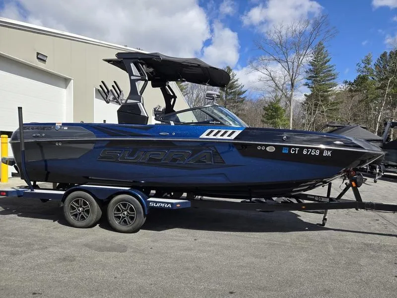 Slide: The Image of 2019 Supra SA boat on trailer, parked outdoors near a building. - 26