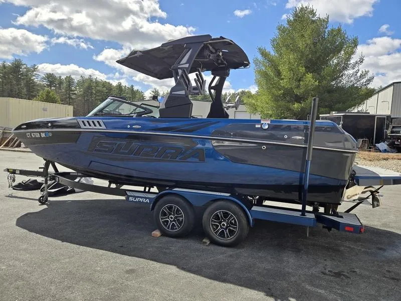 Slide: The Image of 2019 Supra SA boat on trailer, parked outdoors under a partly cloudy sky. - 4