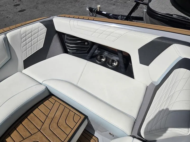 Slide: The Image of 2022 Nautique Super Air Nautique G23 interior with white leather seats and wood accents. - 10
