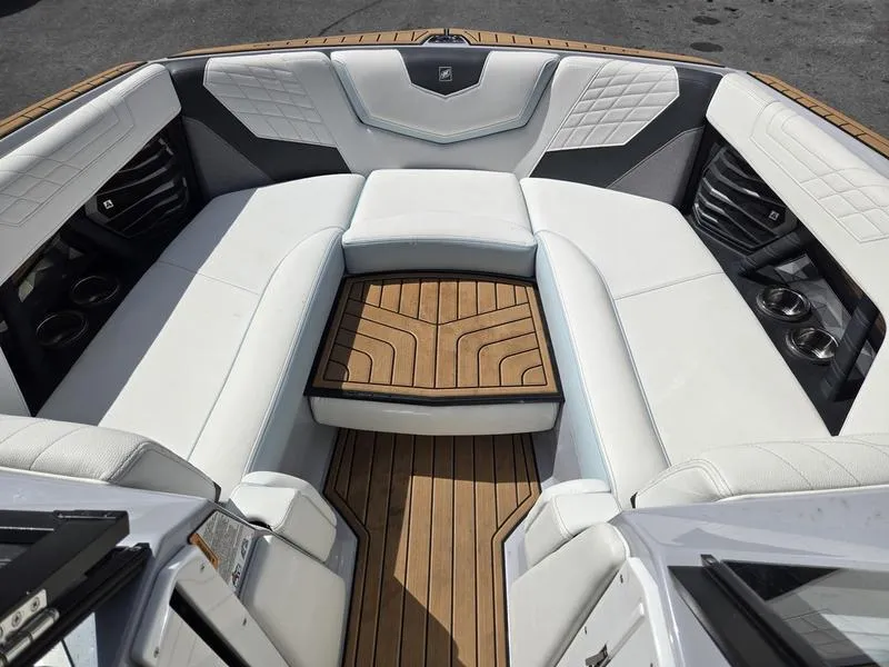 Slide: The Image of Luxurious interior of 2022 Nautique Super Air Nautique G23 boat with white seating and wood flooring. - 8