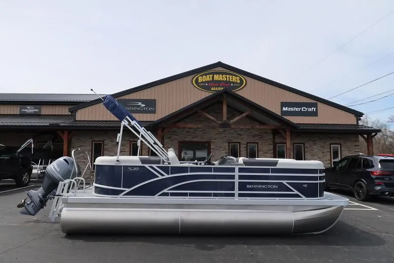 Slide: The Image of 2025 Bennington S Quad Bench 20 SSR pontoon boat outside dealership. - 1