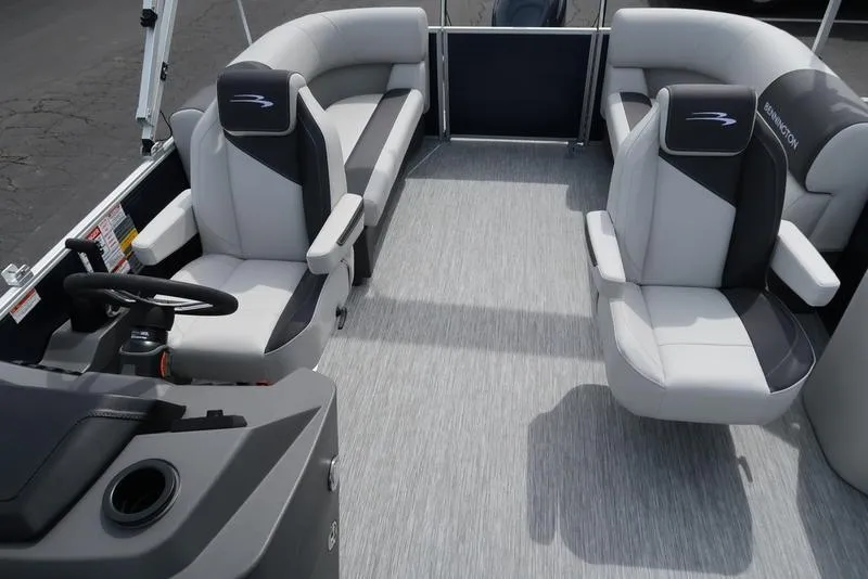 Slide: The Image of 2025 Bennington S Quad Bench 20 SSR pontoon boat interior with gray seating and steering console. - 13