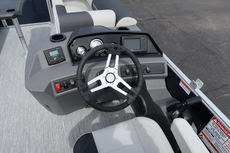 Slide: The Image of 2025 Bennington S Quad Bench 20 SSR boat dashboard with steering wheel and controls. - 16