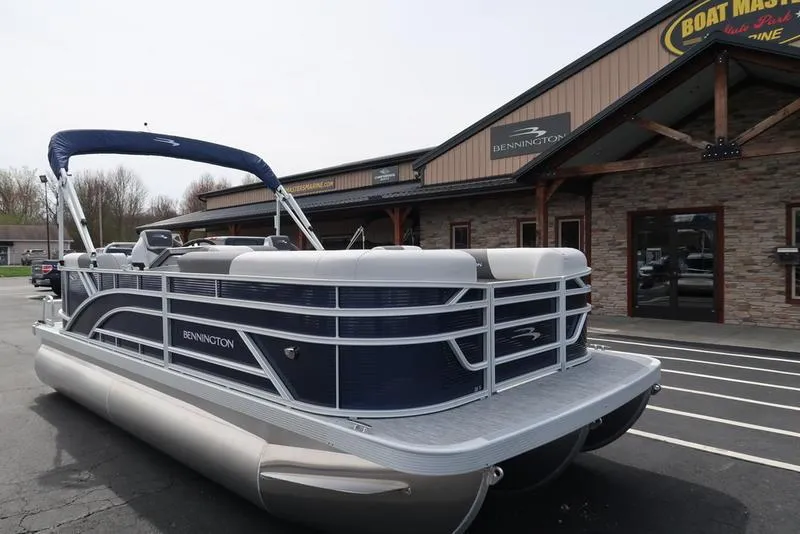 Slide: The Image of 2025 Bennington S Quad Bench 20 SSR pontoon boat parked outside dealership. - 3
