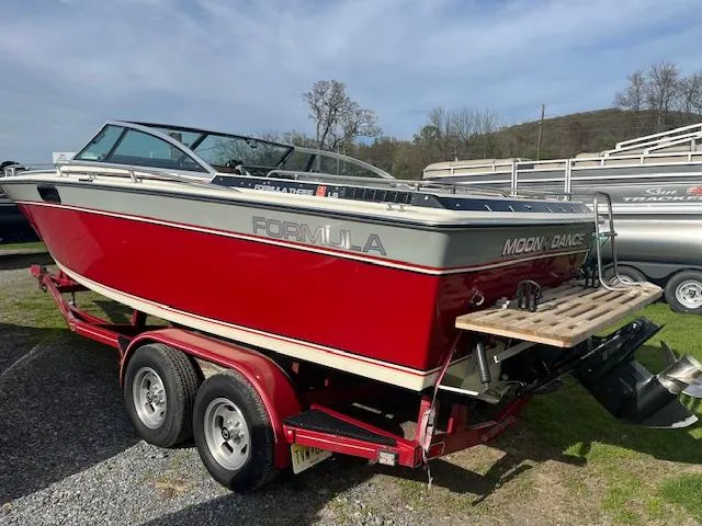 Slide: The Image of 1983 Formula Three LS boat, red and silver, on a trailer in a grassy area. - 2
