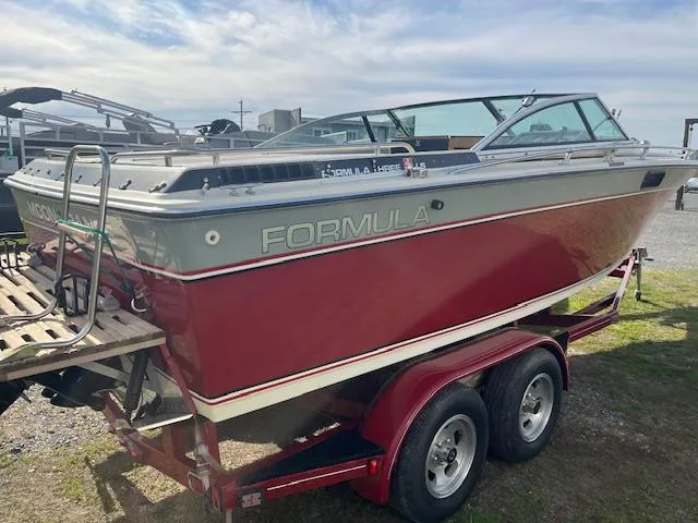 Slide: The Image of 1983 Formula Three LS boat on trailer, red and gray design, parked outdoors. - 5