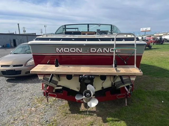 Slide: The Image of 1983 Formula Three LS boat named "Moon Dance" with dual propellers, parked on grass. - 7
