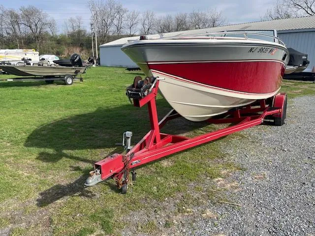 Slide: The Image of 1983 Formula Three LS boat on red trailer, parked on grass near a shed. - 9