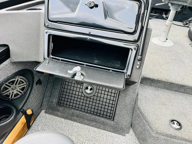 Slide: The Image of 2023 Tracker Targa V-19 WT boat interior with open storage compartment and cup holders. - 29