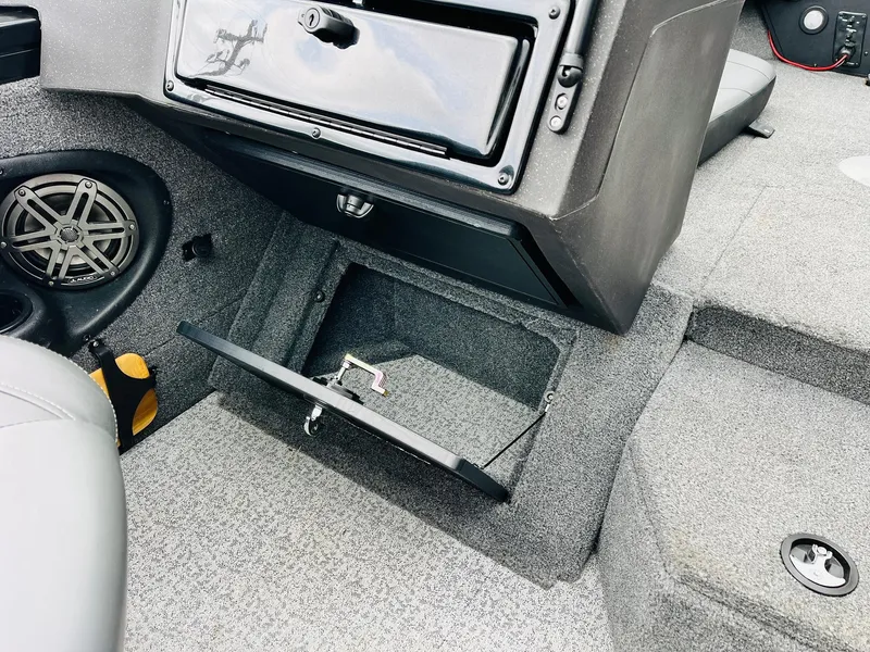 Slide: The Image of 2023 Tracker Targa V-19 WT boat interior with open storage compartment and speaker. - 31