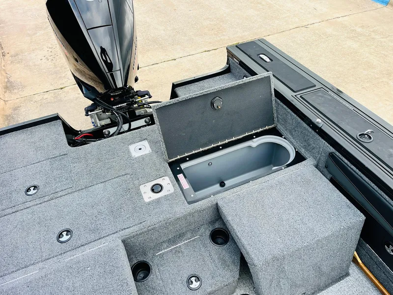 Slide: The Image of 2023 Tracker Targa V-19 WT boat interior with open storage compartment and motor. - 49