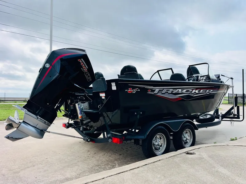 Slide: The Image of 2023 Tracker Targa V-19 WT boat with outboard motor on trailer, parked outdoors. - 5