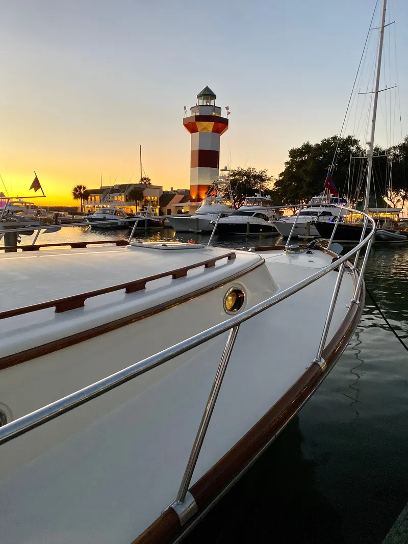 Slide: The Image of 2003 Vicem 51 Classic yacht docked near a lighthouse at sunset. - 11