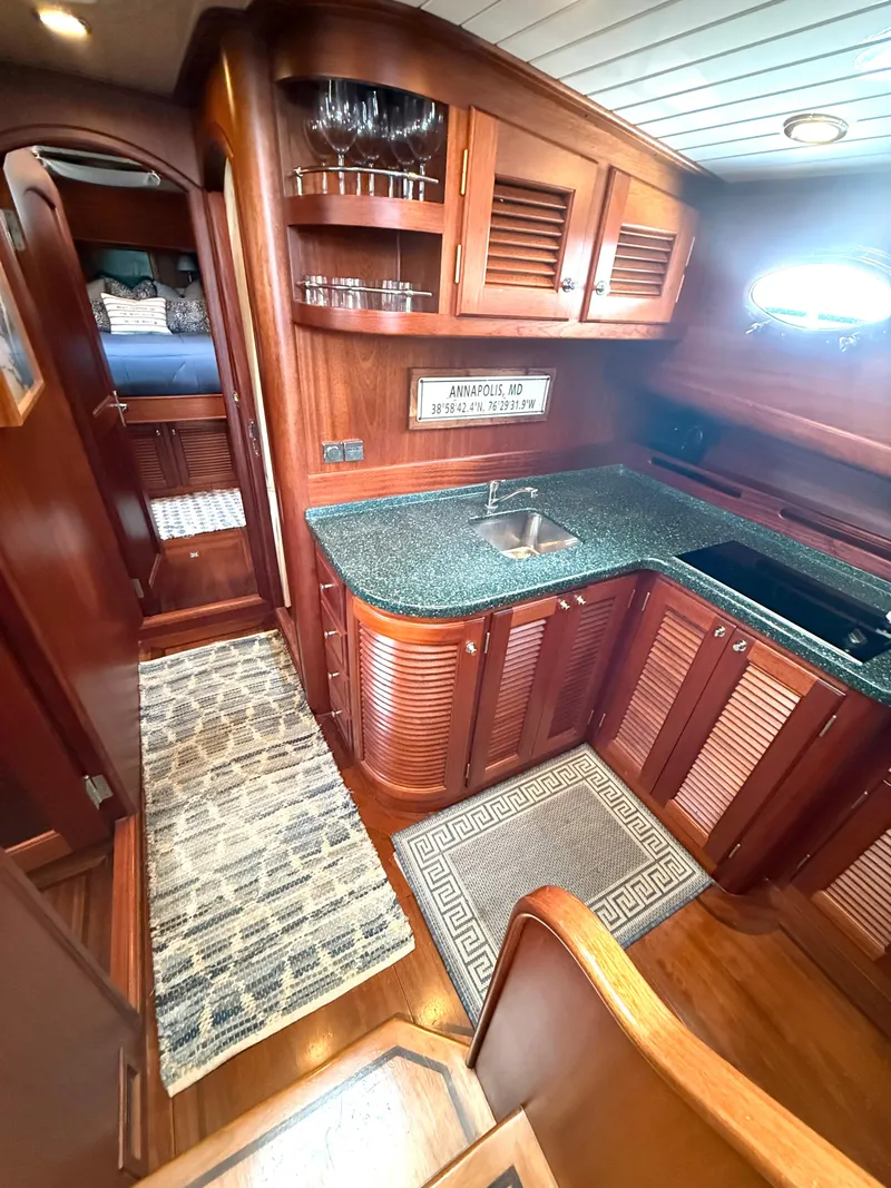Slide: The Image of Luxurious 2003 Vicem 51 Classic yacht interior with elegant wood cabinetry and modern kitchen amenities. - 17