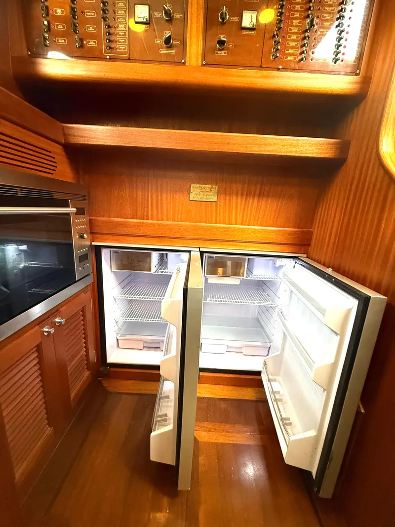 Slide: The Image of 2003 Vicem 51 Classic yacht kitchen with open double refrigerators and wooden cabinetry. - 19