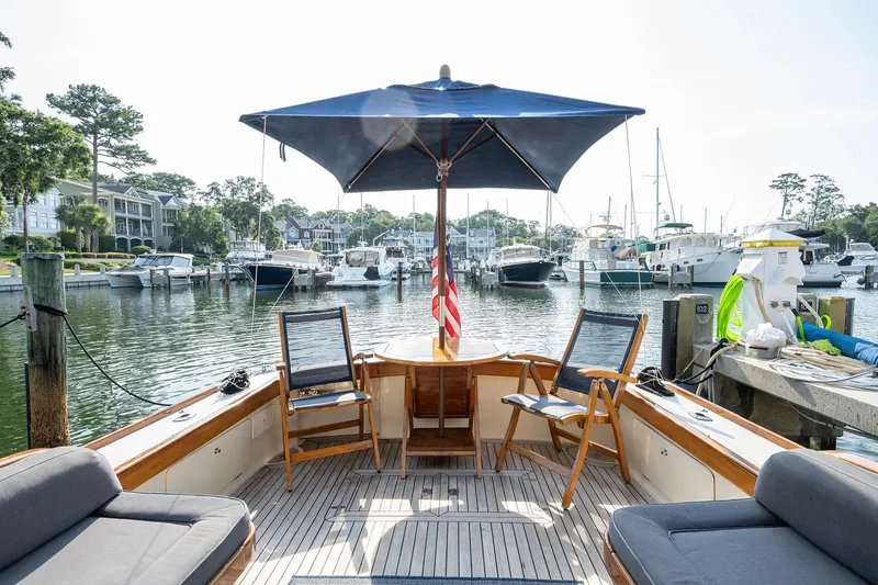 Slide: The Image of 2003 Vicem 51 Classic yacht deck with seating, umbrella, and marina view. - 8