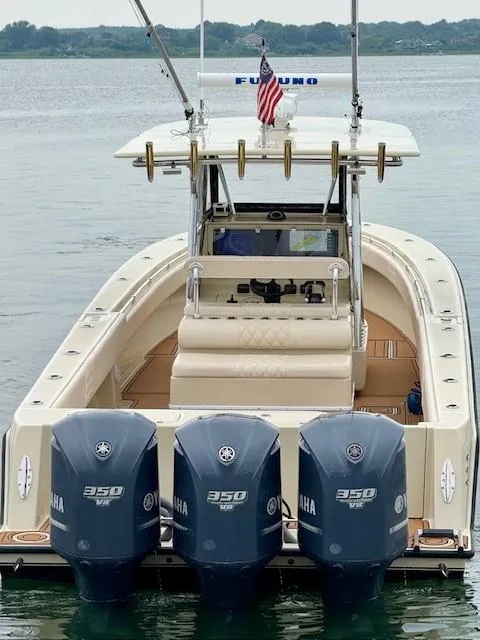 Slide: The Image of 2010 Contender 39 Tournament boat with triple Yamaha 350 engines on calm water. - 2