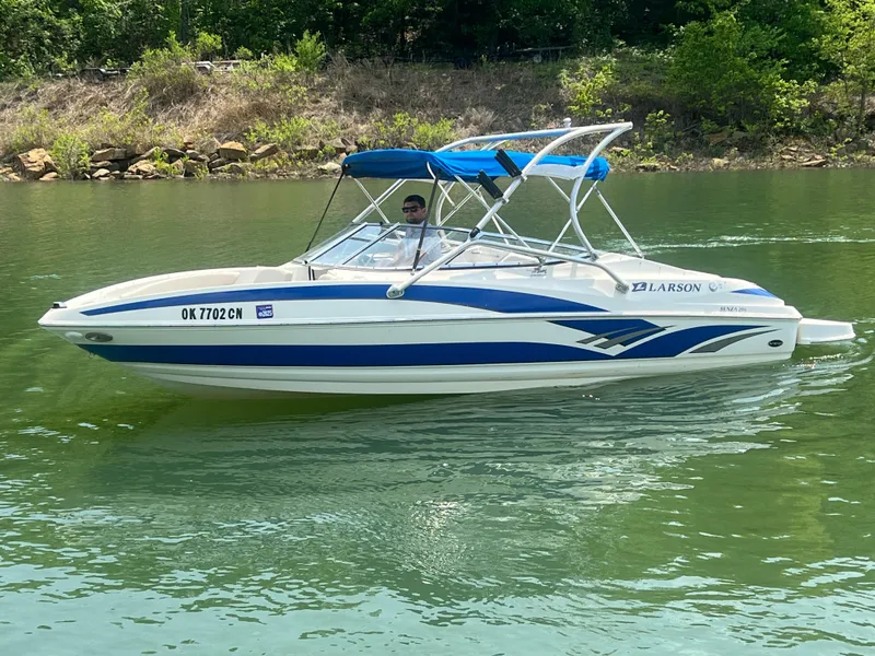 Slide: The Image of 2006 Larson Senza 206 boat with blue accents on a calm lake. - 0