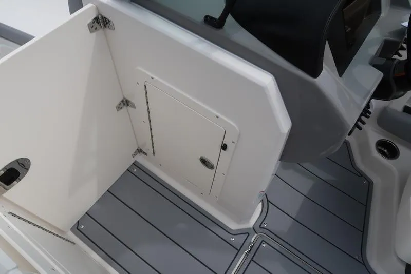 Slide: The Image of 2025 Chaparral 21 SSi boat interior with storage compartment and sleek gray flooring. - 17
