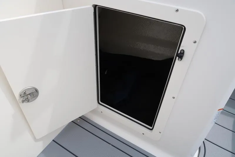 Slide: The Image of Open storage compartment on 2025 Chaparral 21 SSi boat, featuring sleek white design. - 18