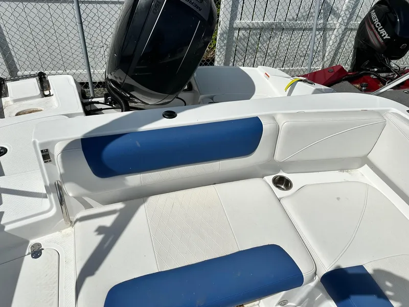 Slide: The Image of 2016 Tahoe 2150 Deck Boat interior with blue and white seating, outboard motor visible. - 10