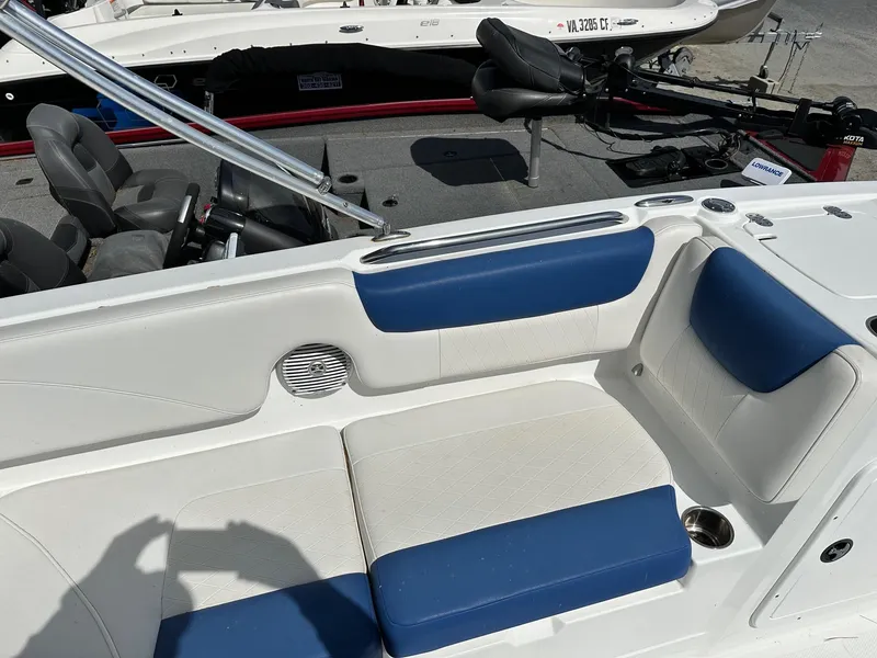 Slide: The Image of 2016 Tahoe 2150 Deck Boat interior with blue and white seating, cup holder, and speaker. - 11